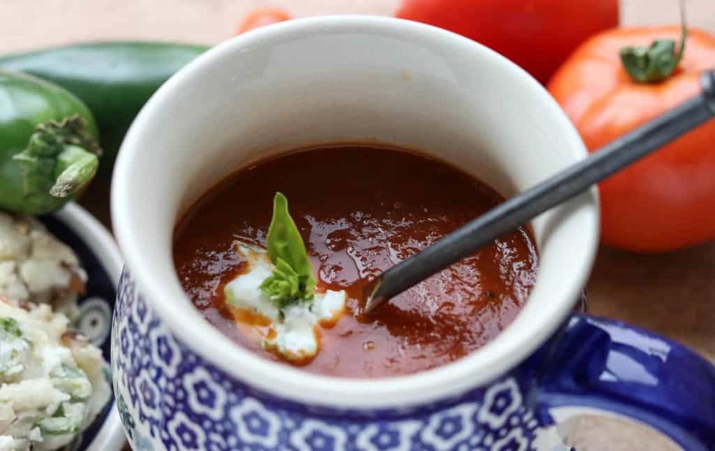 Homemade Fresh Roasted Tomato Jalapeño Soup in a Polish pottery mug with tomatoes, jalapenos and scones