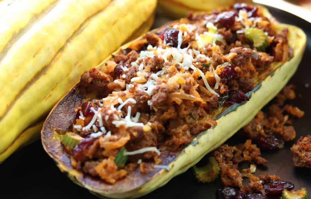 Delicious healthy stuffed Delicata squash with spicy chicken sausage and cranberries from Gourmet Done Skinny with Delicata squash in the background