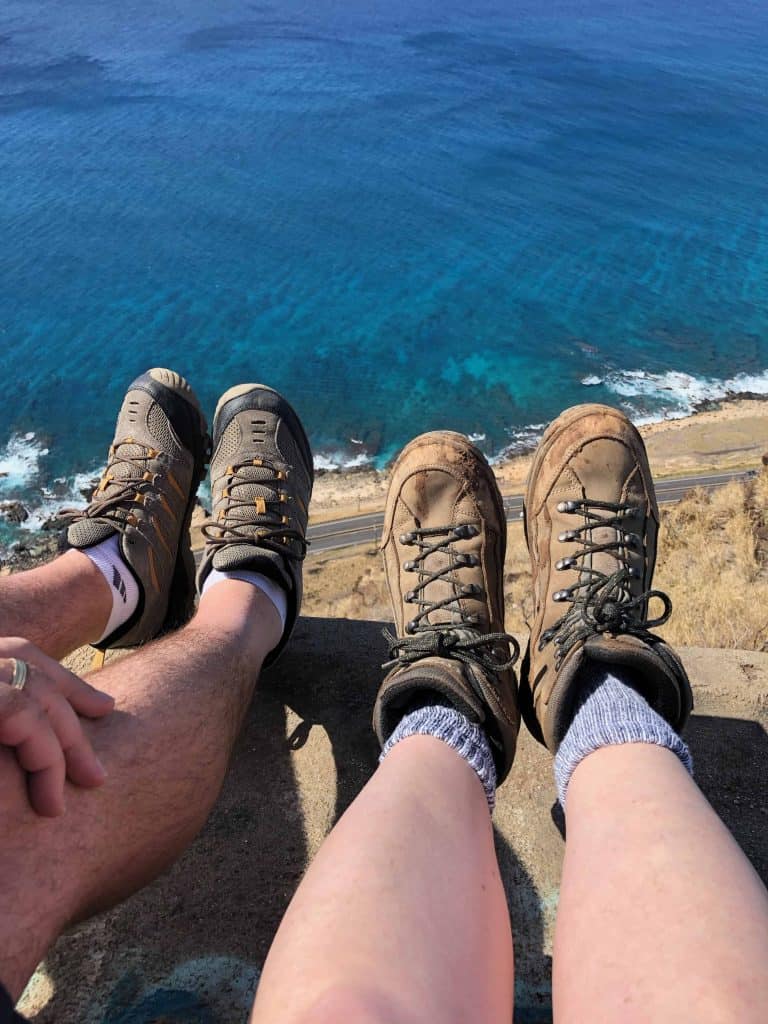 2 pairs of feet overhanging a pill box over the ocean