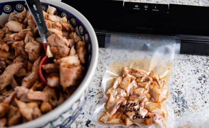 bowl of chopped grilled chicken, vacuum sealer with bag of grilled chicken