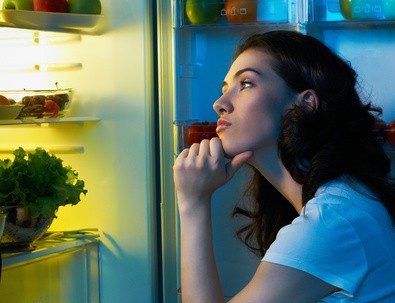 picture of woman contemplating items in fridge