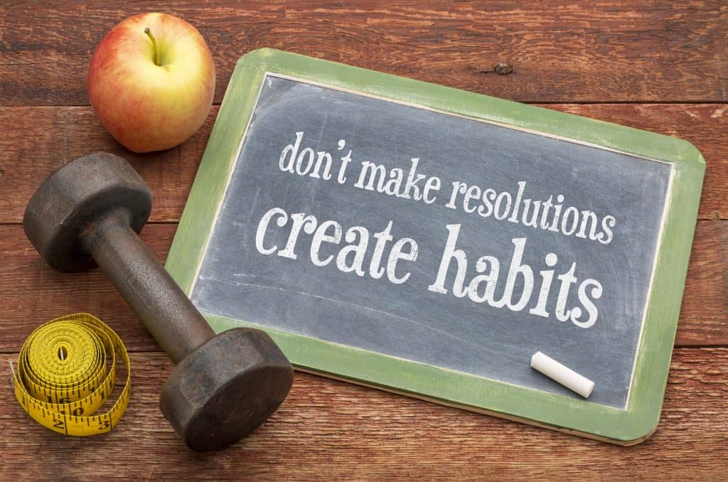 sign that says, "Don't make resolutions, create habits"