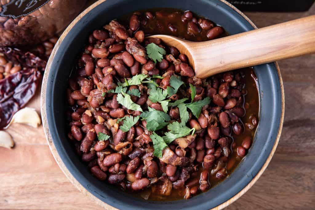 Pinto beans in a bowl with wooden spoon,